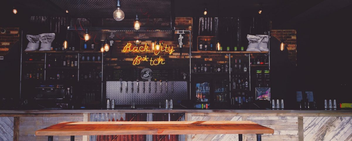 interior of bar with rack city neon sign