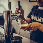 man pouring draft beer